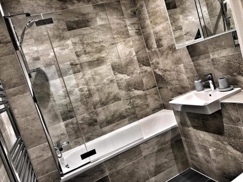 y baño con ducha y lavamanos. en Luxury 2 Bed 2 Bath Apartment 18 mins from Central London - SLEEPS 6, en Watford