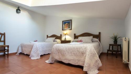 1 dormitorio con 2 camas y mantas blancas en APARTAMENTO 2 4/6 PAX CASA RURAL EL SAUCE. A 2,5 KM DE CUENCA CAPITAL, en Nohales