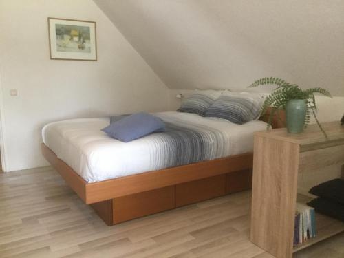 Schlafzimmer mit einem Bett mit weißer Bettwäsche und blauen Kissen in der Unterkunft B&B De Eikenhorst in Elsloo