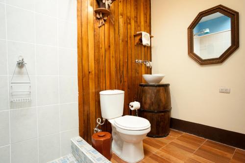 a bathroom with a toilet and a wooden door at Hotel Vintage "Casa las Flores" in Quetzaltenango