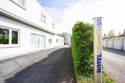 a parking sign on a street next to a white building at Hotel Sauer Garni in Neu Isenburg