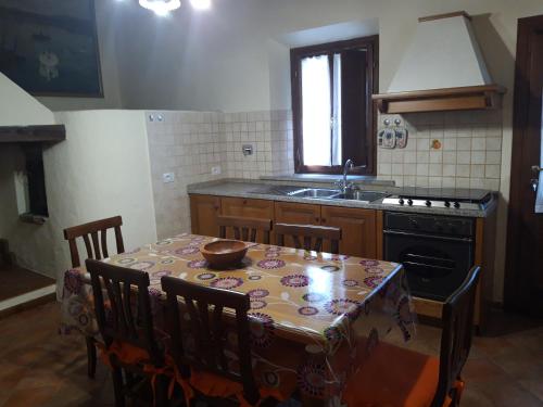 a kitchen with a table and chairs and a sink at La Casa di Ida in Fornello