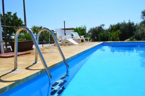 a swimming pool with a wooden deck next to a swimming pool at VILLA L&M in Floridia