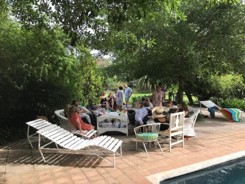 a group of people sitting around a table by a pool at Hotel Boutique Quinta Maria in Santa Cruz