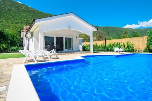 a villa with a swimming pool in front of a house at Villa Mirna in Mostar