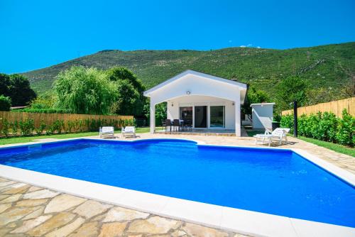 a swimming pool in a yard with a house at Villa Mirna in Mostar