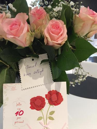 un ramo de rosas rosas con una tarjeta y una nota en Hotel Prélude, en Aalter