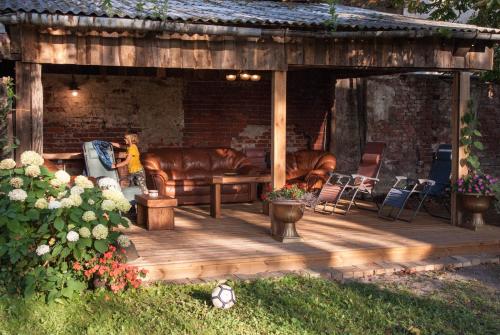 a wooden deck with a couch and chairs on it at Ezera Maja in Liepāja