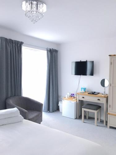 ein Schlafzimmer mit einem Bett, einem Stuhl und einem Schreibtisch in der Unterkunft Prestbury Bed & Breakfast in Salisbury