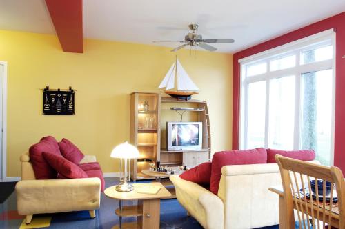 sala de estar con 2 sofás y TV en Chalets Multivoile 4 Saisons, en Trois-Rivières
