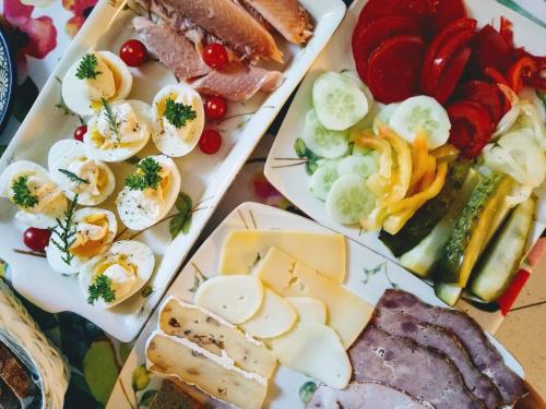 a tray of food with eggs and meats and vegetables at Apartamenty Zielona Góra in Zielona Góra