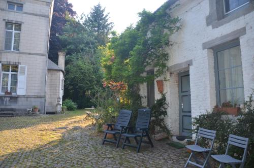 a group of chairs sitting outside of a house at La Gentilhommière du Château de Ragnies in Ragnies