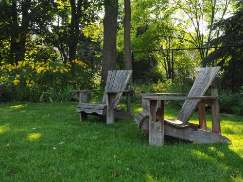 two wooden benches and a picnic table in the grass at Parkside House in Barrie