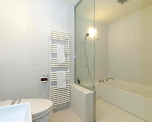 a bathroom with a shower and a toilet and a sink at Niseko Landmark View in Kutchan