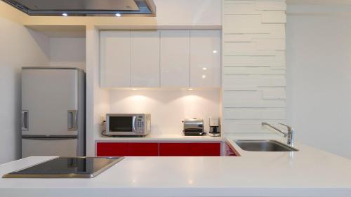 a kitchen with a sink and a refrigerator at Niseko Landmark View in Kutchan