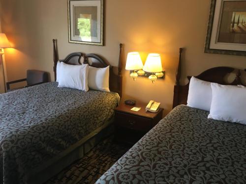 a hotel room with two beds and two lamps at Days Inn by Wyndham Picayune in Picayune