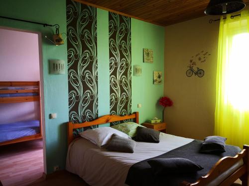 una camera con un letto in una stanza con pareti verdi di Hotel Ô Fil de L'ô a Marseillette