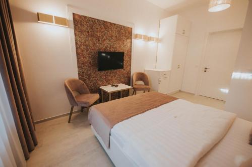 a bedroom with a bed and a tv on a wall at Hotel Marabella in Sibiu