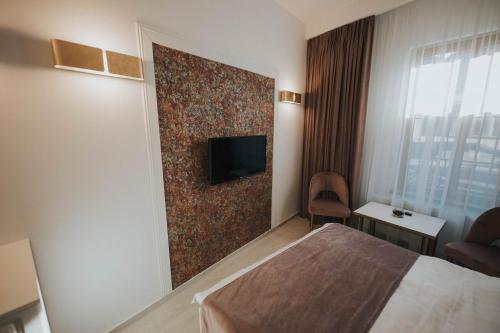 a hotel room with a bed and a tv on a wall at Hotel Marabella in Sibiu