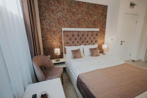 a hotel room with two beds and a chair at Hotel Marabella in Sibiu