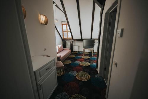 a hallway with a room with a couch and a television at Hotel Marabella in Sibiu