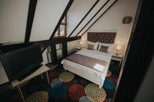 a bedroom with a bed and a flat screen tv at Hotel Marabella in Sibiu