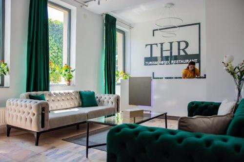 a living room with two couches and a table at Hotel THR Center in Curtea de Argeş
