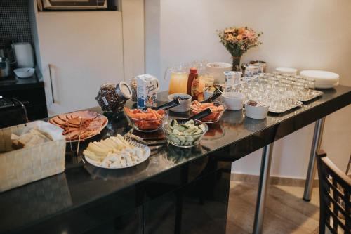 a buffet of food on a counter with plates of food at Hotel Marabella in Sibiu