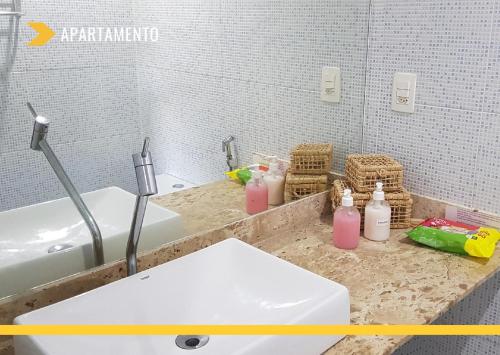 a bathroom with a sink and a white tub at Atlantic City Apart Service in Salvador