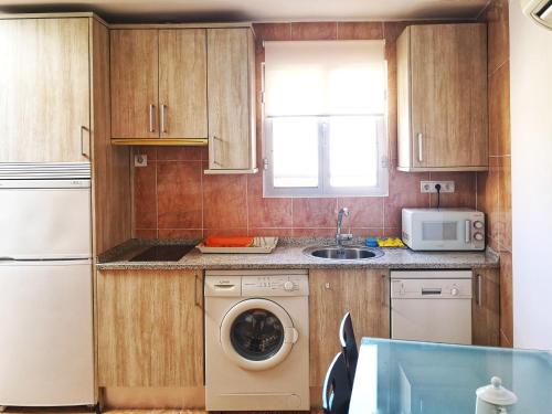 cocina con lavadora y microondas en Apartamentos Cocó, en Ávila