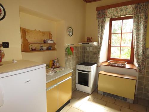 a small kitchen with a stove and a window at Penzion Severka in Rokytnice v Orlických Horách