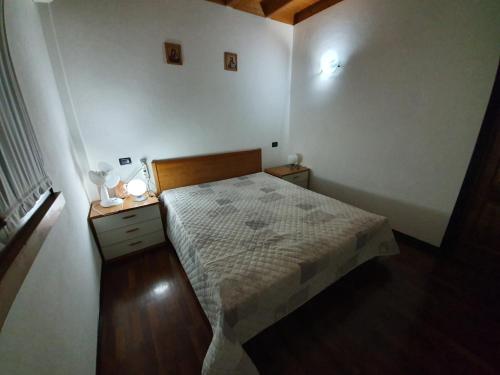 a small white bedroom with a bed and a night stand at garda felice in Desenzano del Garda