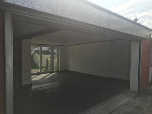an empty garage of a building with a window at City Retreat, Spacious 4 Bed House, Games Room, Parking, Hot Tub & BBQ in Cardiff