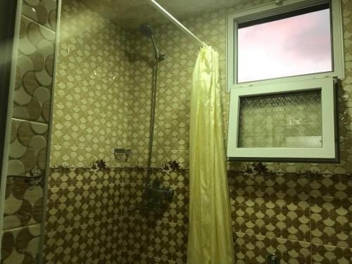 a shower with a shower curtain and a window at House Dea Dea in Chakvi