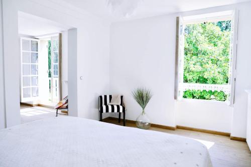 Goupillières的住宿－GLYCINES COUNTRY GUESTHOUSE，白色的卧室设有一张大床和一个窗户