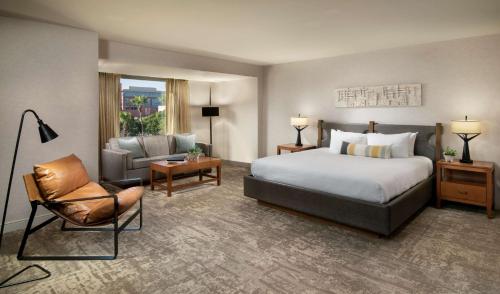 
a living room with a bed, chair and a lamp at Tempe Mission Palms, a Destination by Hyatt Hotel in Tempe
