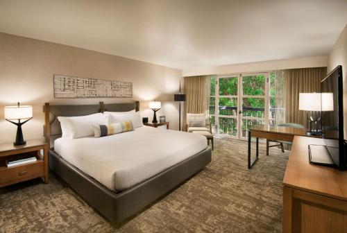 una camera d'albergo con letto, scrivania e TV di Tempe Mission Palms, a Destination by Hyatt Hotel a Tempe