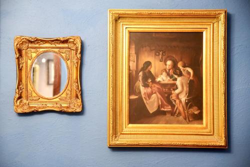 a picture of a painting on a wall with a mirror at The Lodge in Cospicua