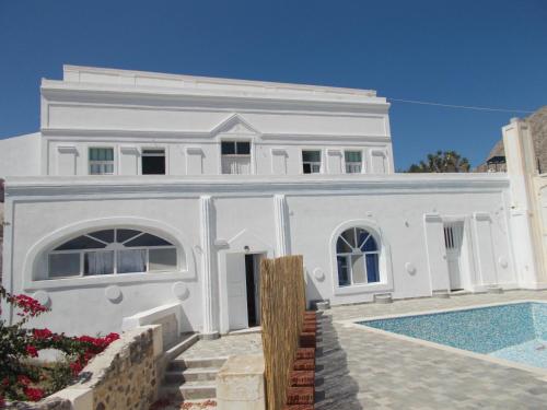 une maison blanche avec une piscine en face de celle-ci dans l'établissement Loukas Kontos Traditional House, à Emporio