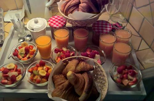 ein Tablett mit Gebäck und Obst auf dem Tisch in der Unterkunft A l'Orée du Pin in Puyricard