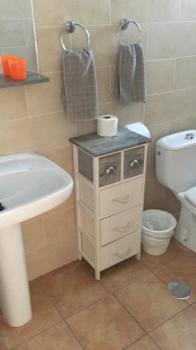 a bathroom with a white sink and a toilet at Apartamentos Alberto in Morro del Jable