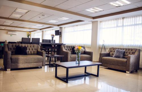 una sala de espera con sofás y una mesa con flores. en Hotel ALO! Express en Torreón