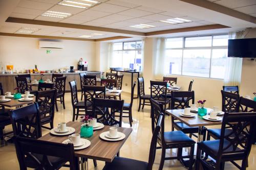 uma sala de jantar com mesas e cadeiras de madeira em Hotel ALO! Express em Torreón