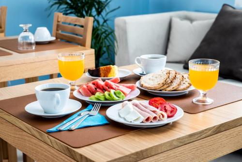 een tafel met borden met ontbijtproducten en -dranken bij AZUL in Zambujeira do Mar