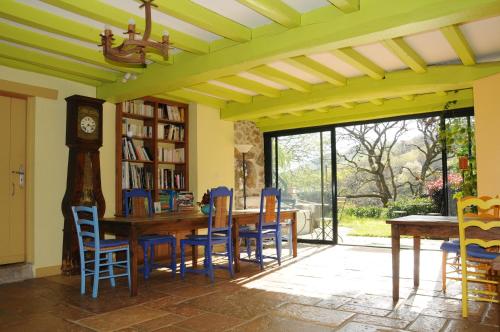 une salle à manger avec une table, des chaises et une horloge dans l'établissement Domaine Xixtaberri, à Cambo-les-Bains