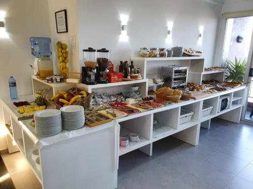 a buffet with a lot of food on shelves at Hotel Foxos in A Lanzada