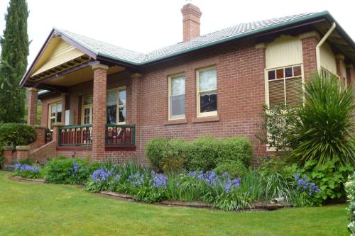 a brick house with purple flowers in the yard at Donalea Bed and Breakfast & Riverview Apartment in Castle Forbes Bay