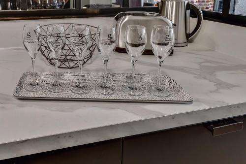 quatre verres à vin assis sur un plateau sur un comptoir dans l'établissement Élégance - DisneyLand Paris - Vallée Village - 7 à 9 personnes, à Serris