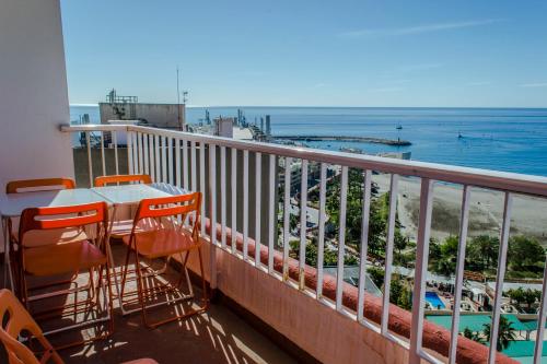 een balkon met een tafel en stoelen en de oceaan bij Magnifique vue à 100m de la plage in Benalmádena