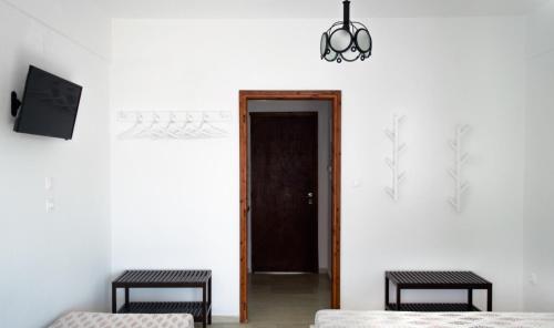 a room with two beds and a black door at House Charistos in Neos Marmaras